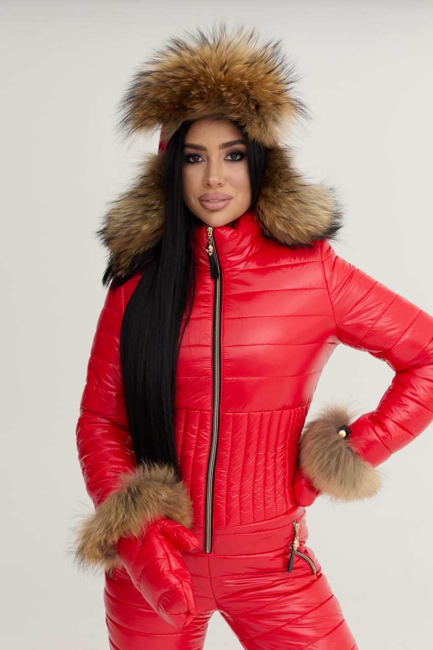 Person wearing a red puffer suit with fur trim on a plain background