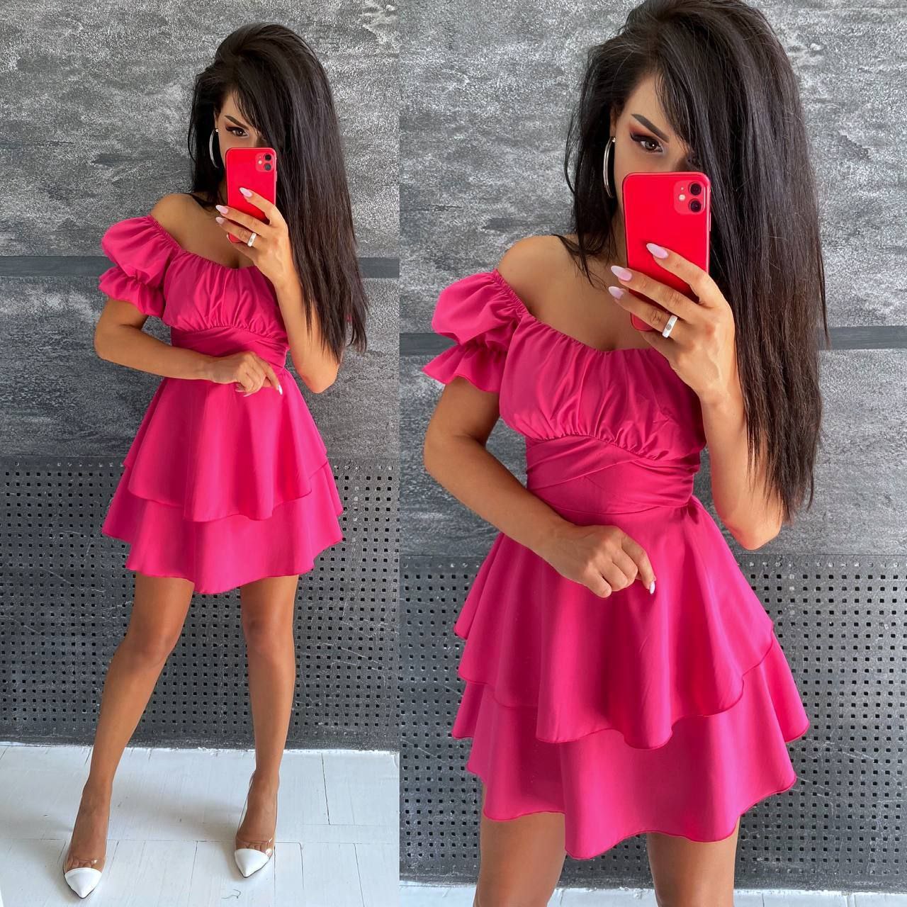 Woman taking a mirror selfie wearing a pink dress against a gray textured wall.