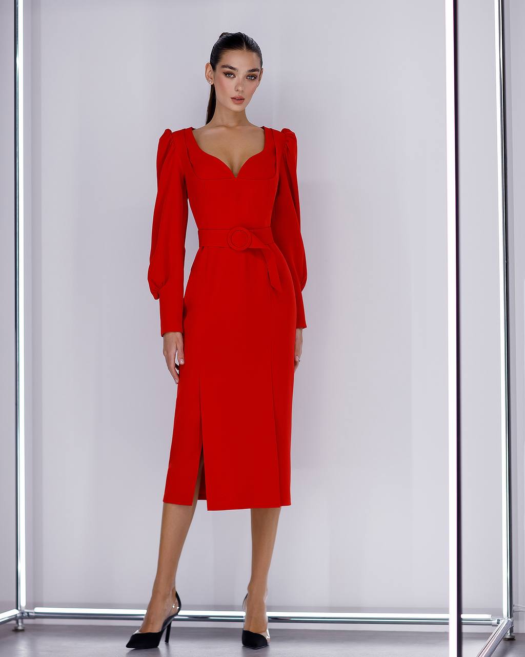 Woman wearing a red dress with puff sleeves against a white background