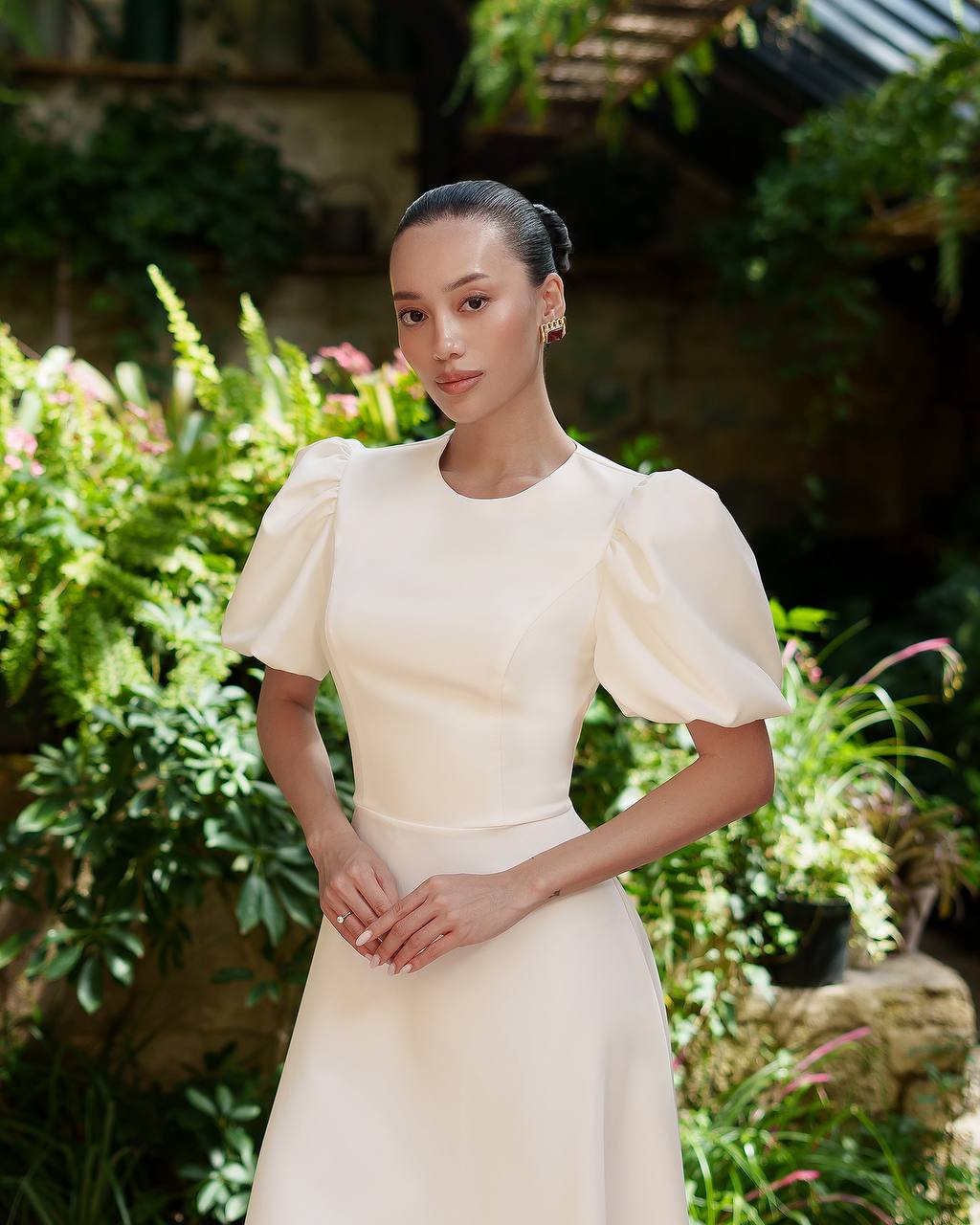 Woman in a white dress standing in a garden setting