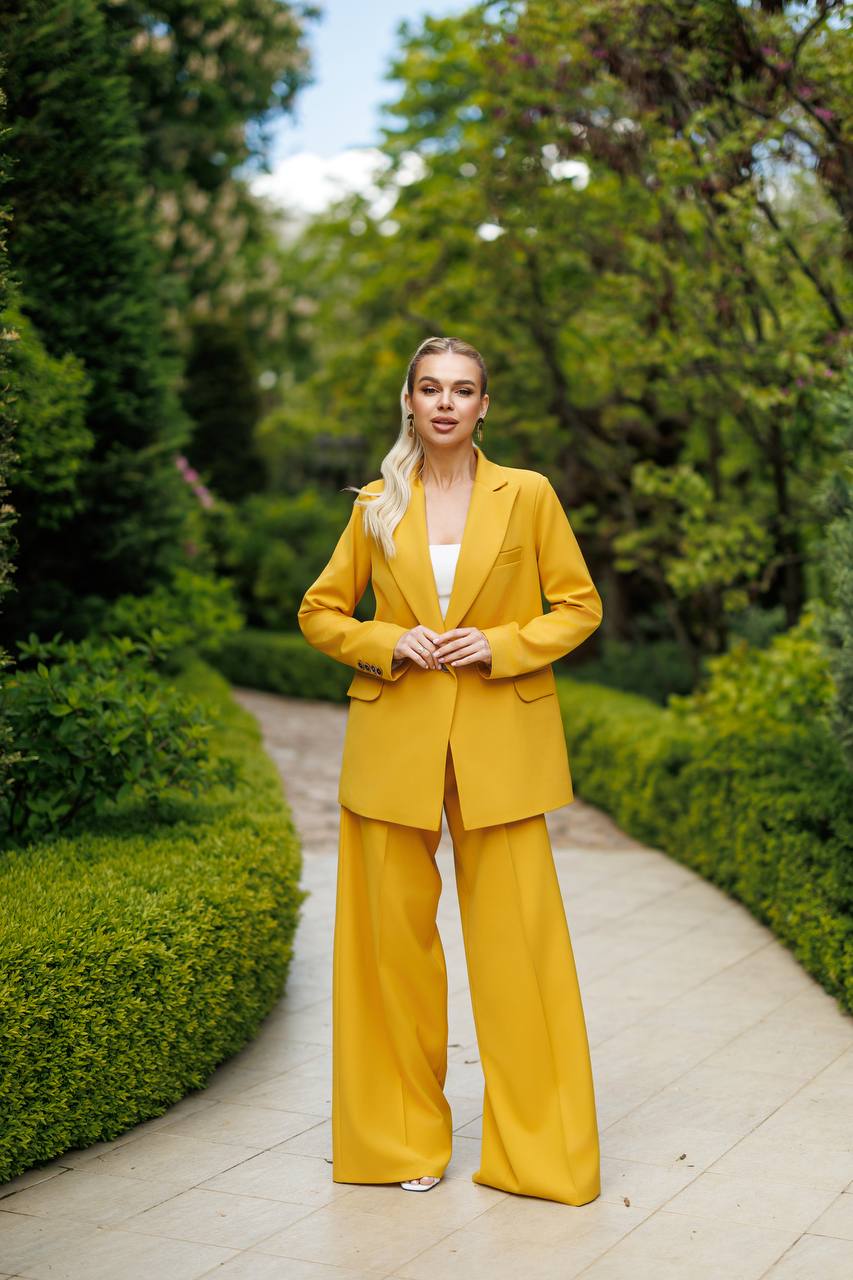 Woman in a yellow suit standing in a garden