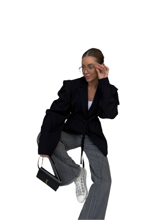 Person wearing a black coat and gray pants sitting on a white background