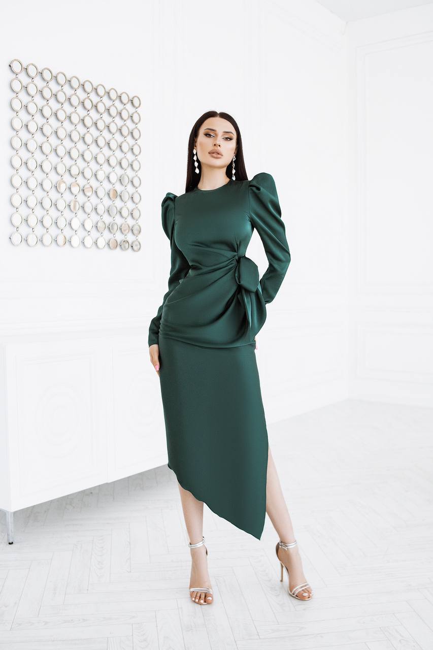 Woman wearing a green dress with puffed sleeves against a white background