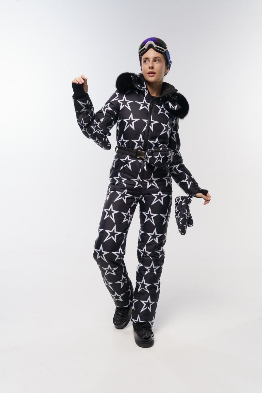 Person wearing a black and white star-patterned ski suit on a white background