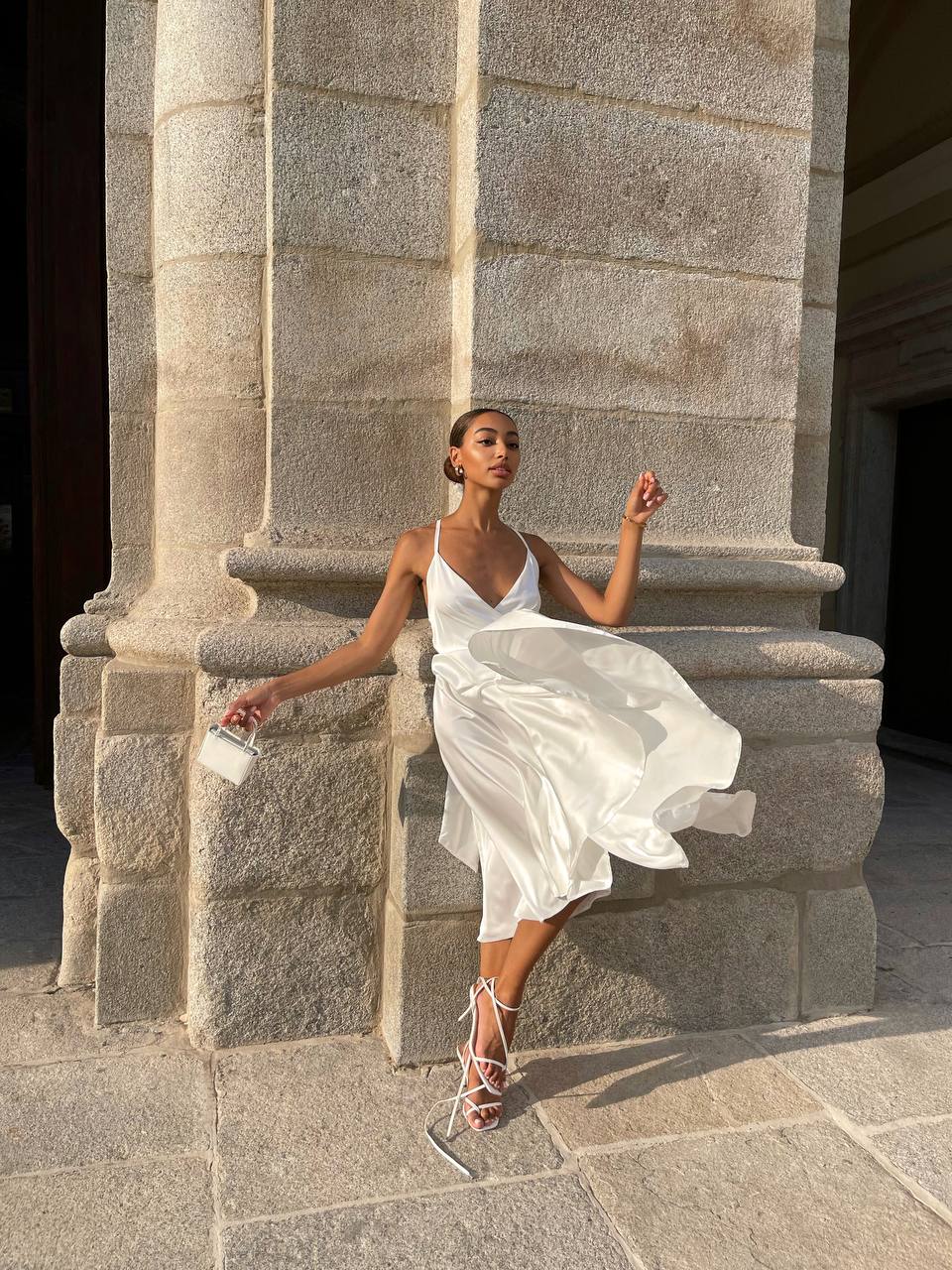 Woman in a white dress sitting on stone steps outdoors