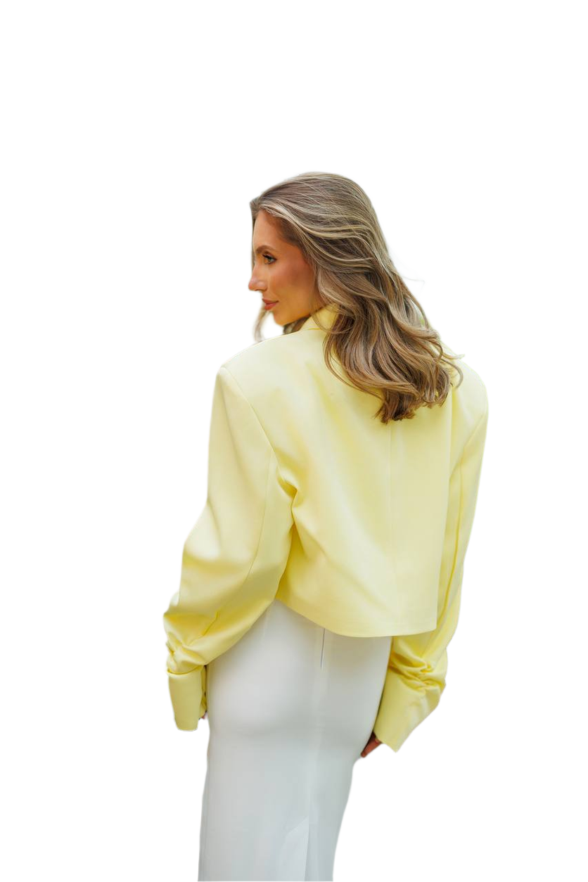 Woman wearing a light yellow blouse and white pants on a white background