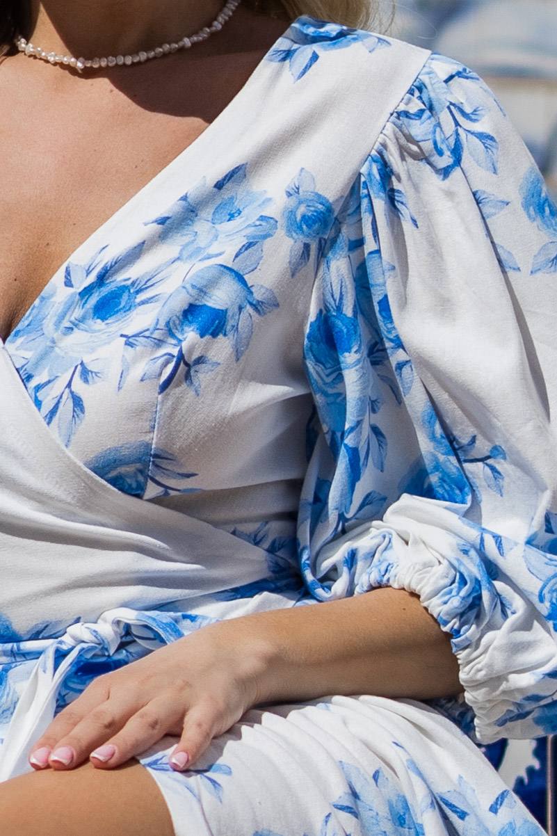 White garment with blue floral pattern worn by a person, close-up view.