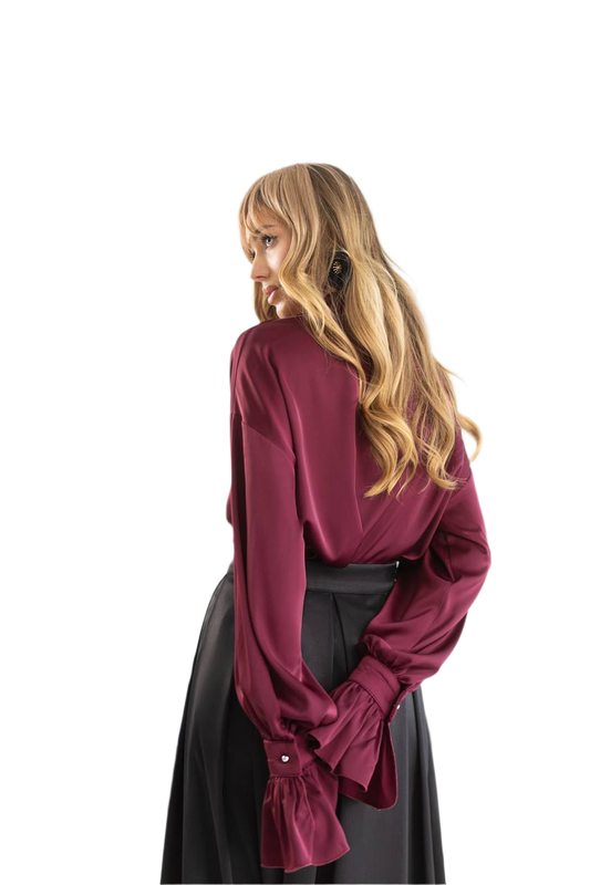 Person wearing a burgundy blouse and black skirt on a white background