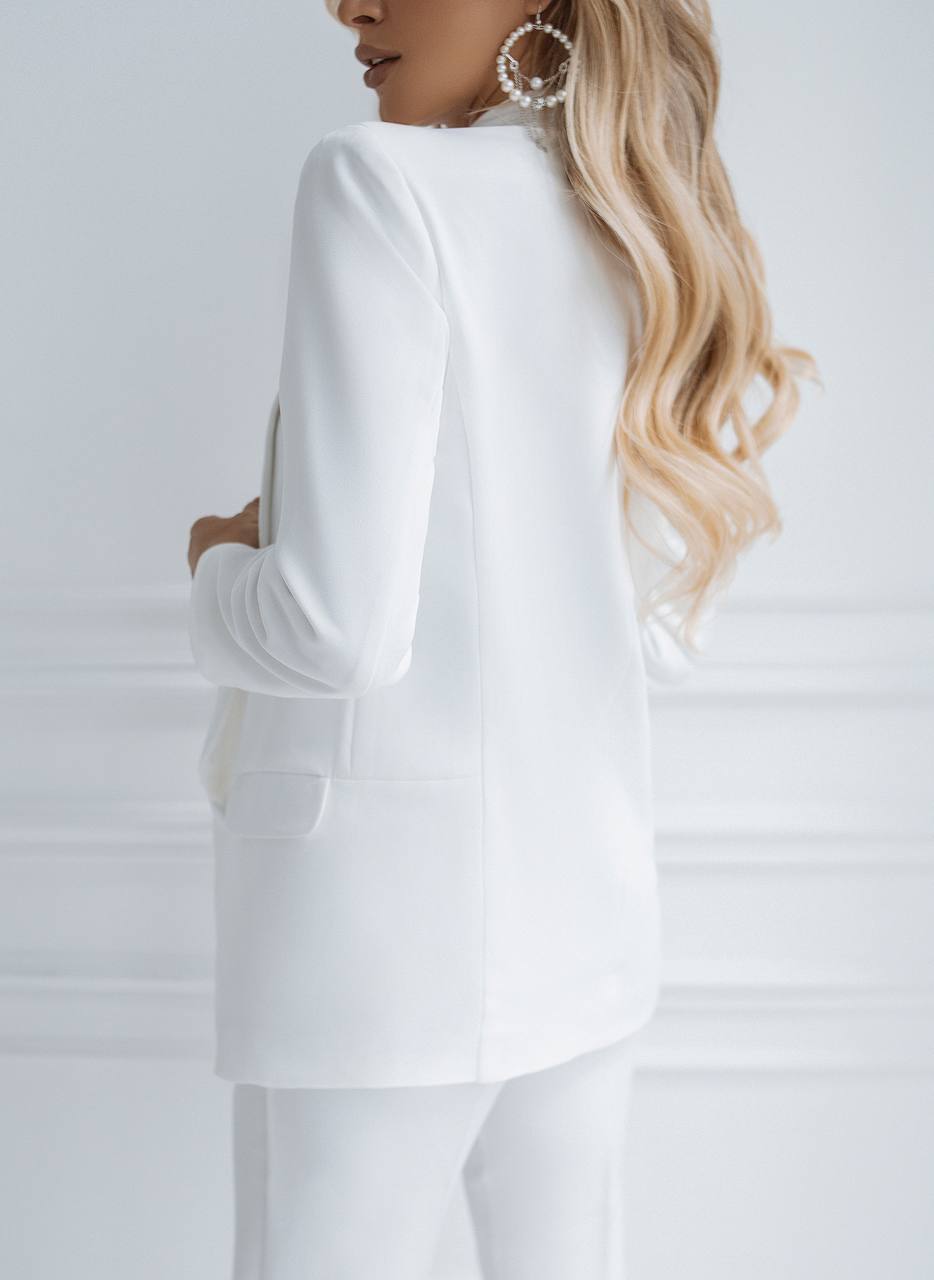 Person wearing a white outfit with a plain background