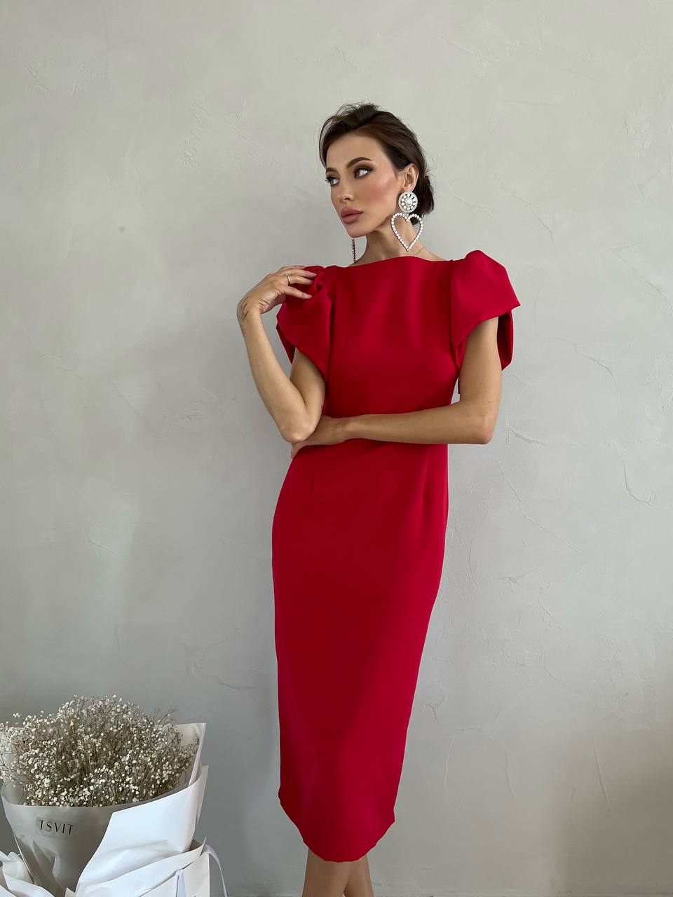 Woman wearing a red dress against a plain background