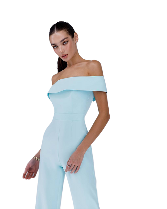Woman wearing a light blue off-shoulder jumpsuit on a white background