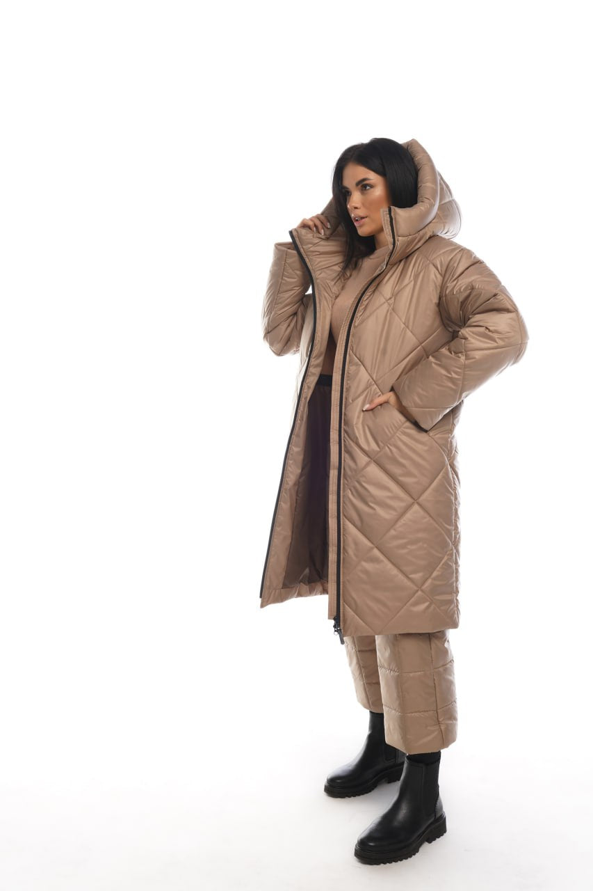 Woman wearing a beige quilted coat on a white background