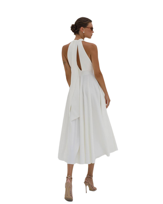 Woman wearing a white dress with a halter neck and open back on a white background
