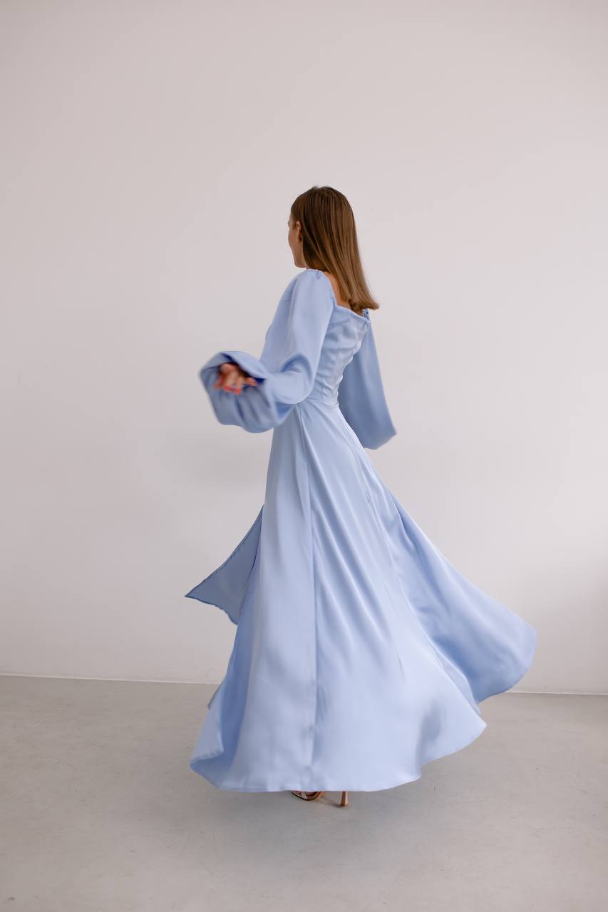 Woman wearing a light blue dress against a plain background