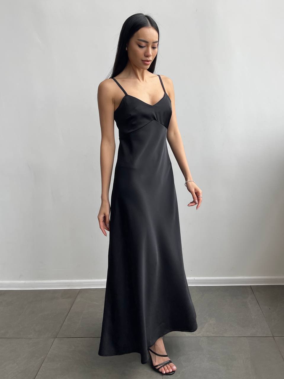 Woman wearing a black dress against a plain background