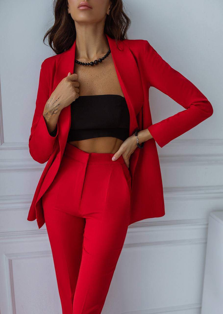 Person wearing a red suit with a black top against a white background