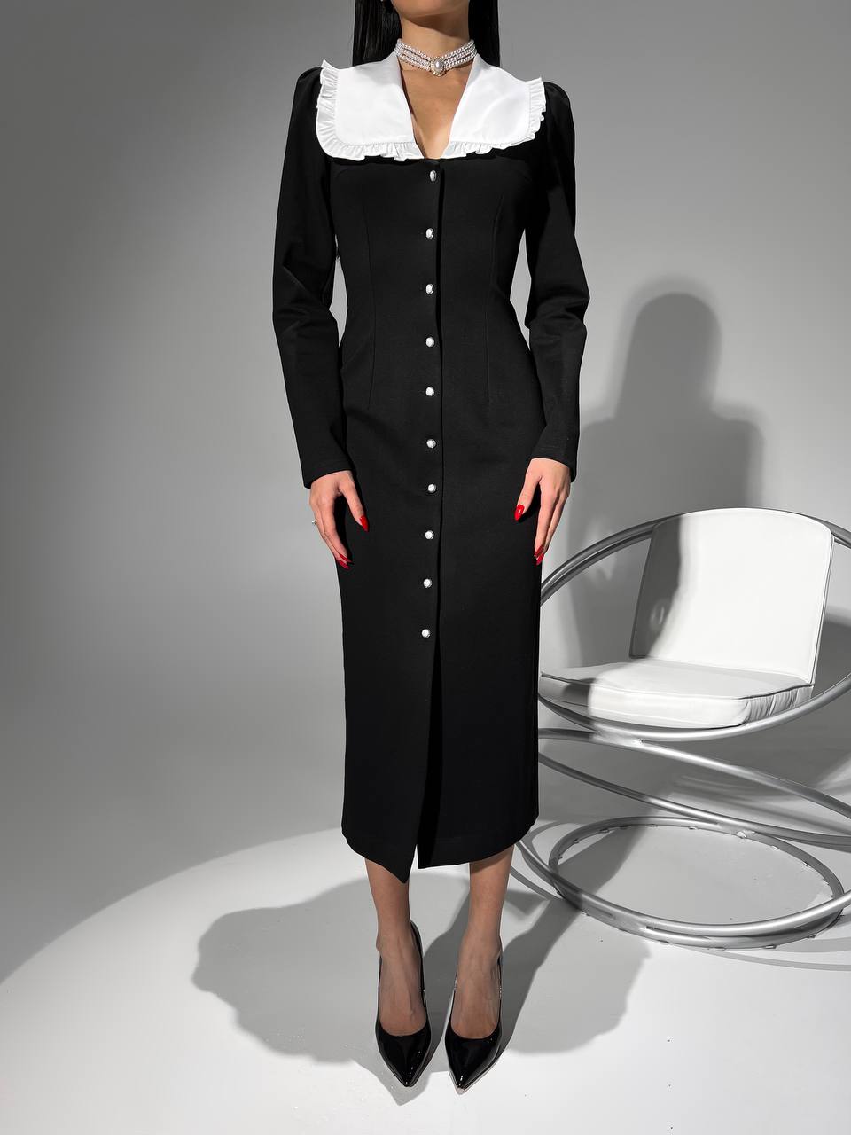 Black dress with white collar on a gray background