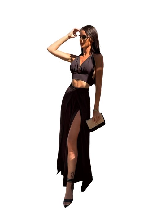 Woman wearing a black outfit with a high slit on a white background