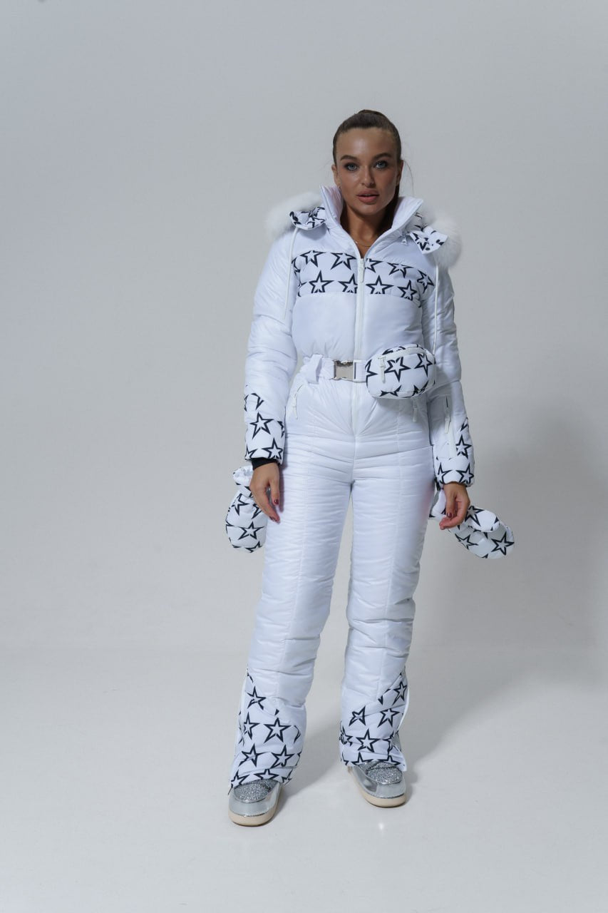 Person wearing a white ski suit with star patterns on a plain background