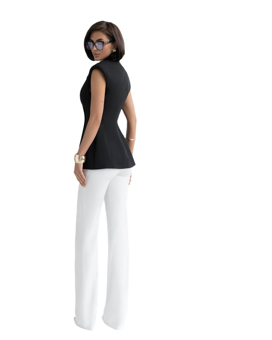 Woman wearing a black sleeveless top and white pants on a white background