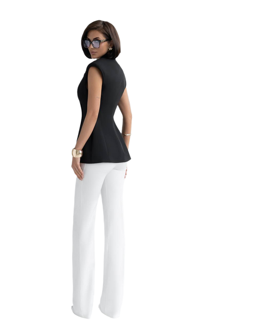 Woman wearing a black sleeveless top and white pants on a white background