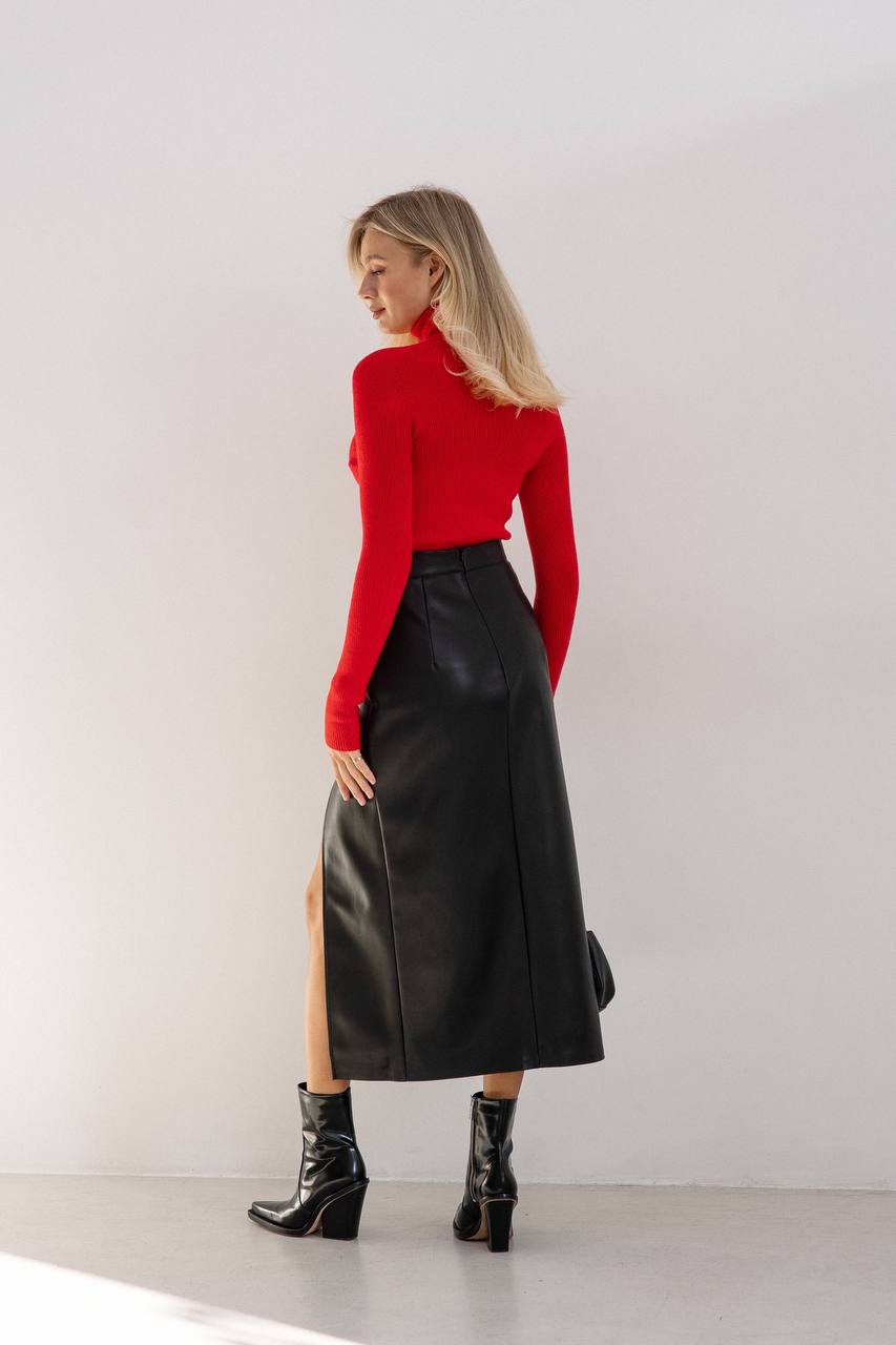 Woman wearing a red sweater and black leather skirt against a white background