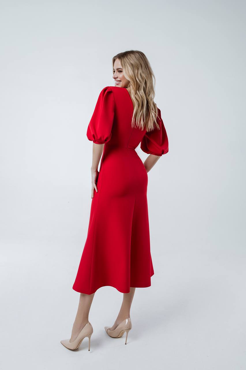 Woman wearing a red dress with puff sleeves on a white background