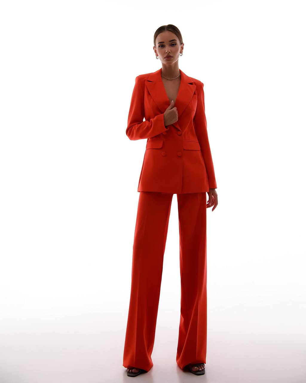 Woman wearing a bright red suit on a white background