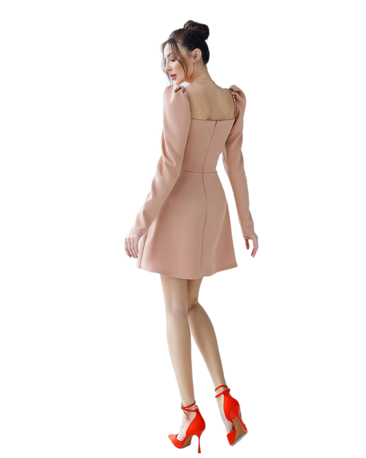 Woman wearing a beige dress with long sleeves on a white background