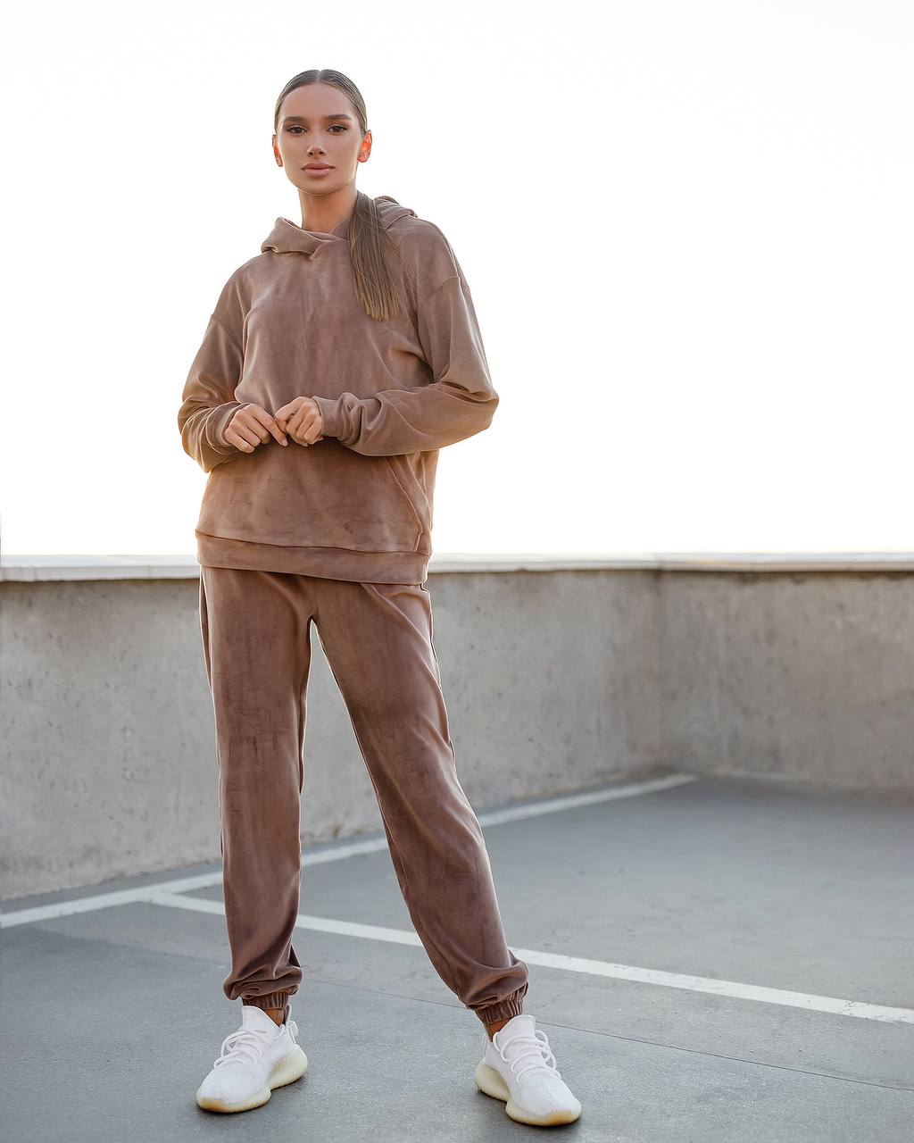 Person wearing a brown tracksuit on a rooftop.
