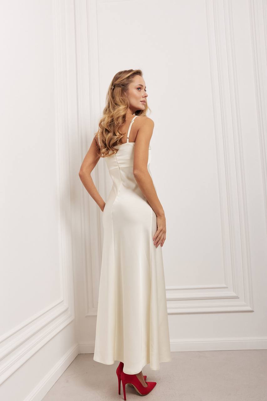 Woman in a white dress standing against a white wall