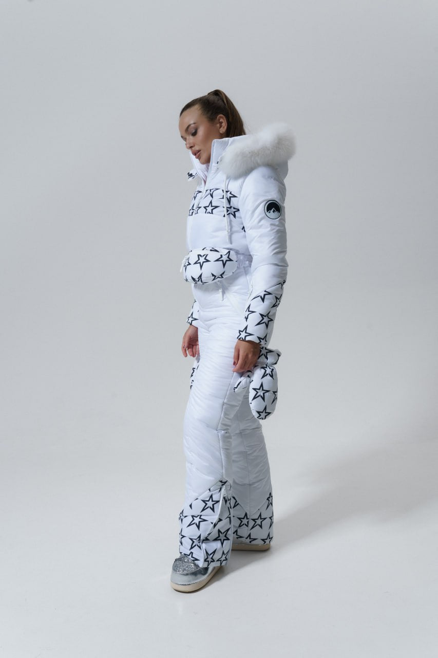 Person wearing a white snowsuit with star patterns on a light gray background