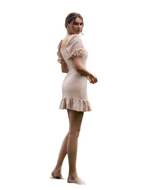 Woman wearing a beige dress with puffed sleeves and ruffled hem on a white background