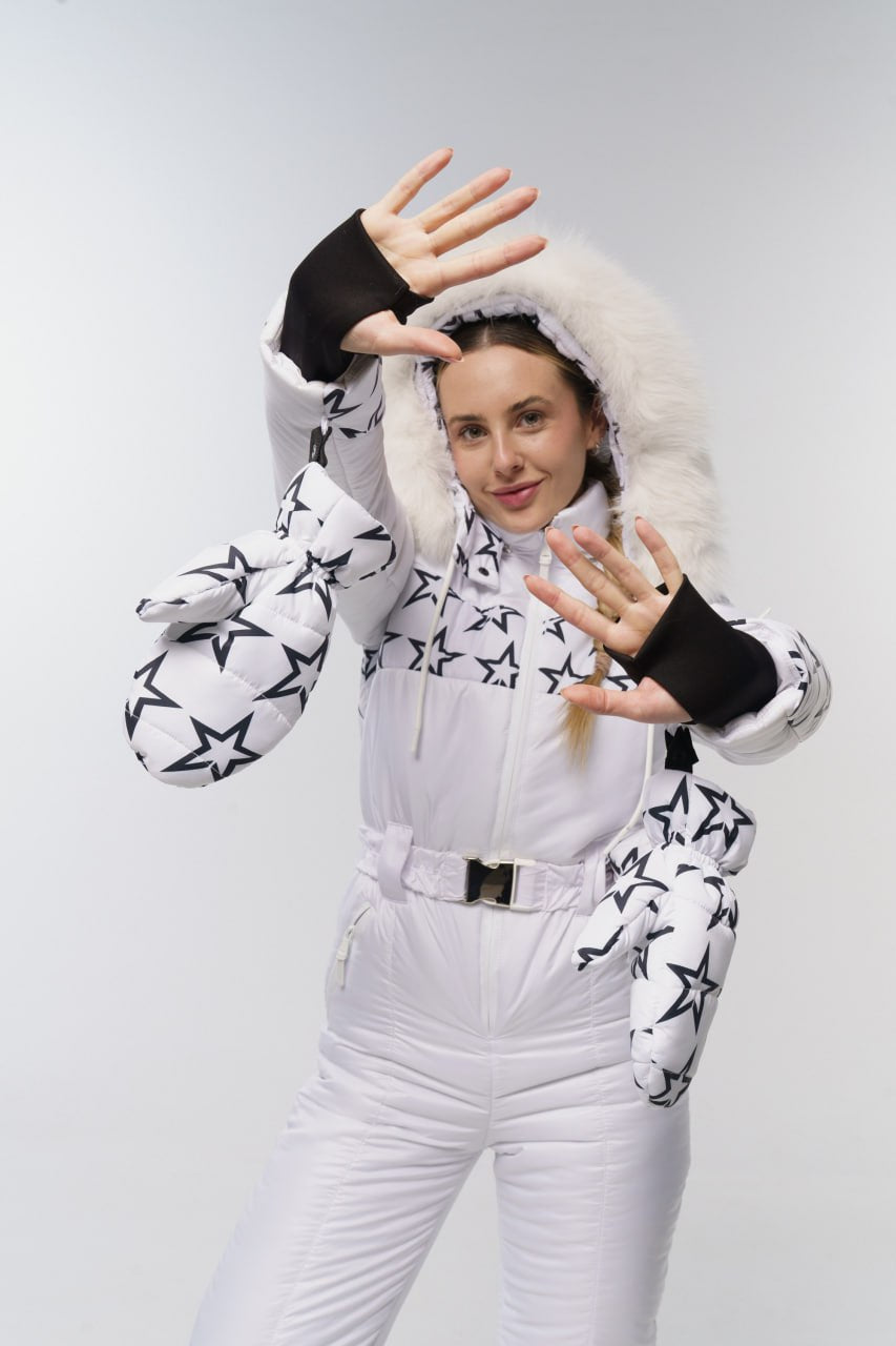 Person wearing a white snowsuit with star patterns on a plain background