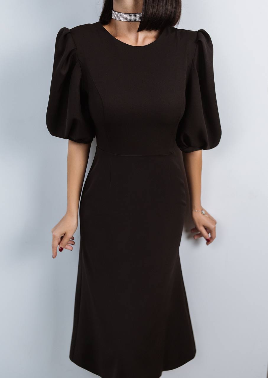 Black dress with puffed sleeves on a plain background