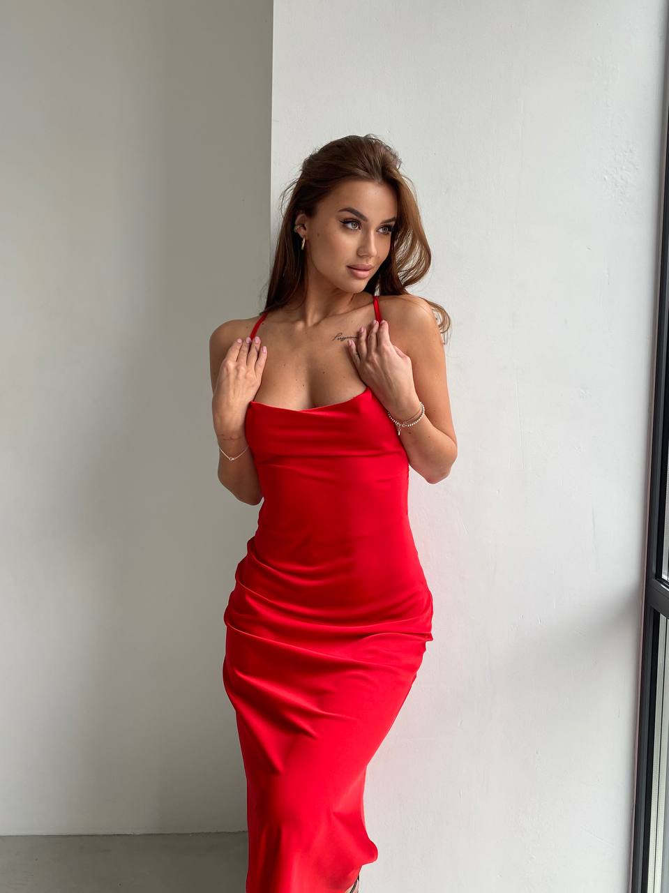 Woman wearing a red dress against a plain background