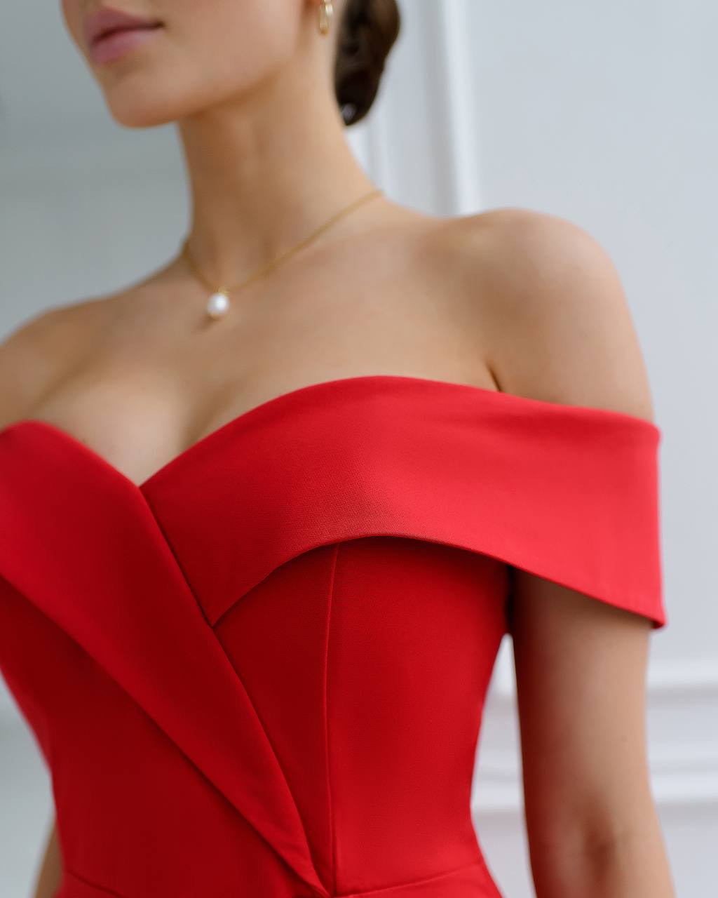 Red off-shoulder dress worn by a person with a blurred background
