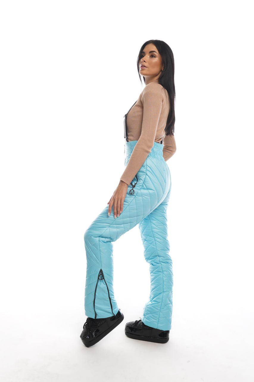 Woman wearing light blue pants with black accents on a white background