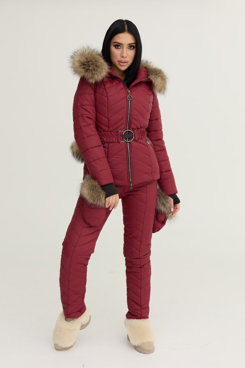 Person wearing a red puffer suit with fur trim on a white background