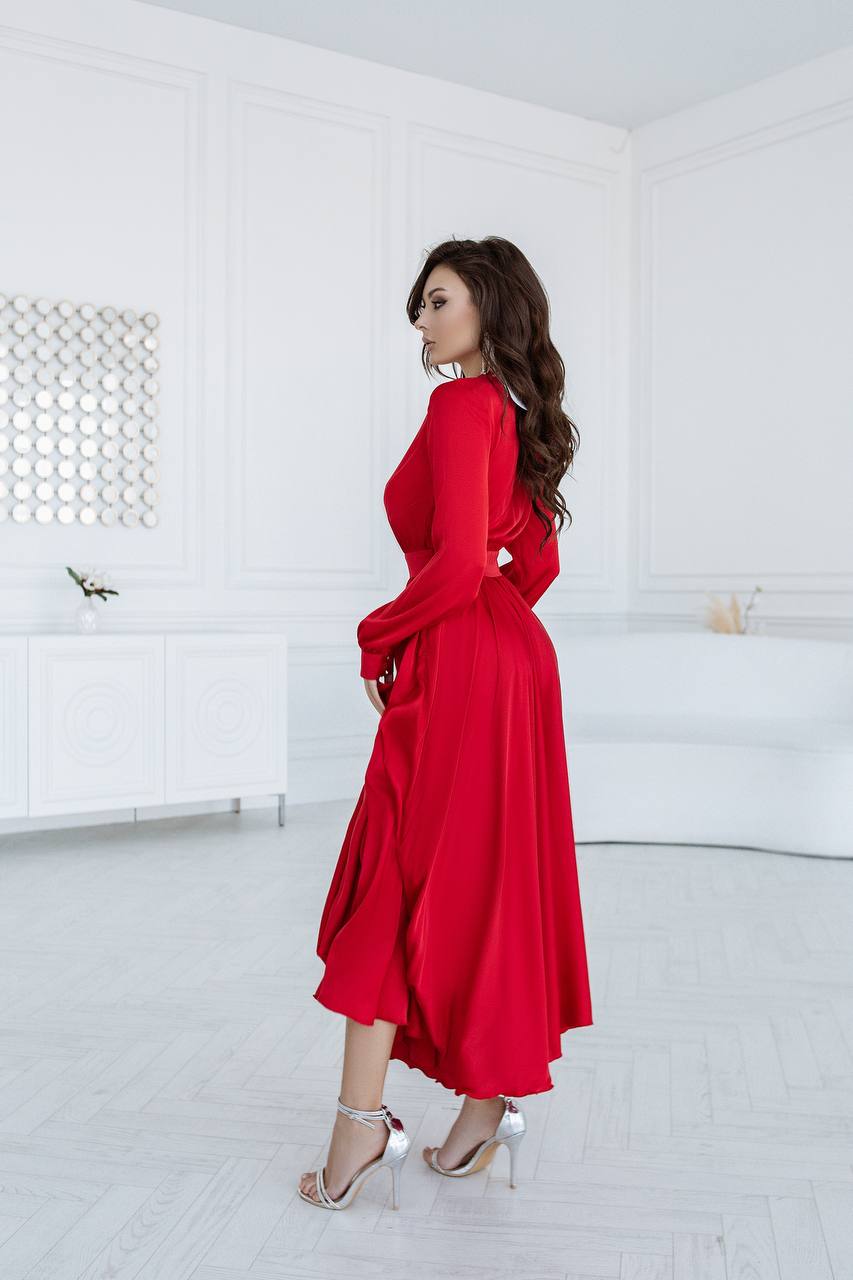 Woman in a red dress standing in a minimal white room
