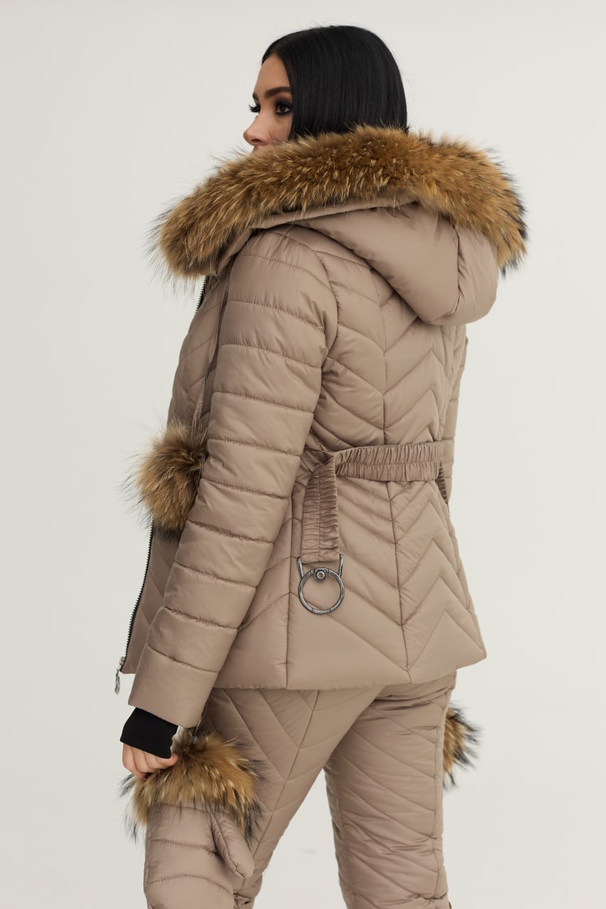 Person wearing a beige puffer coat with fur trim on a white background