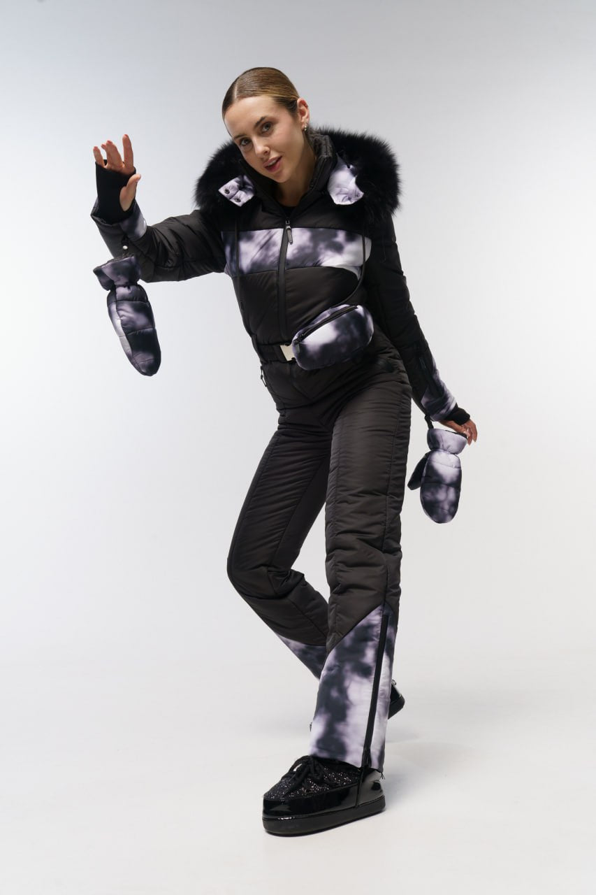 Person wearing a black and gray outfit with fur trim on a white background