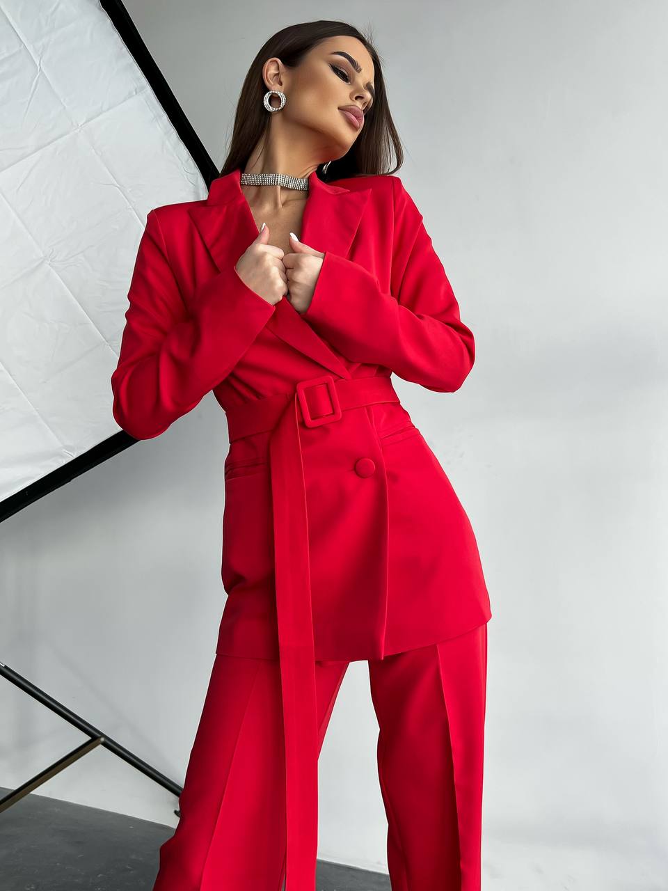 Woman wearing a red outfit posing against a white background