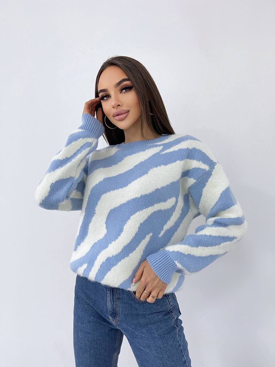 Woman wearing a blue and white striped sweater against a plain background