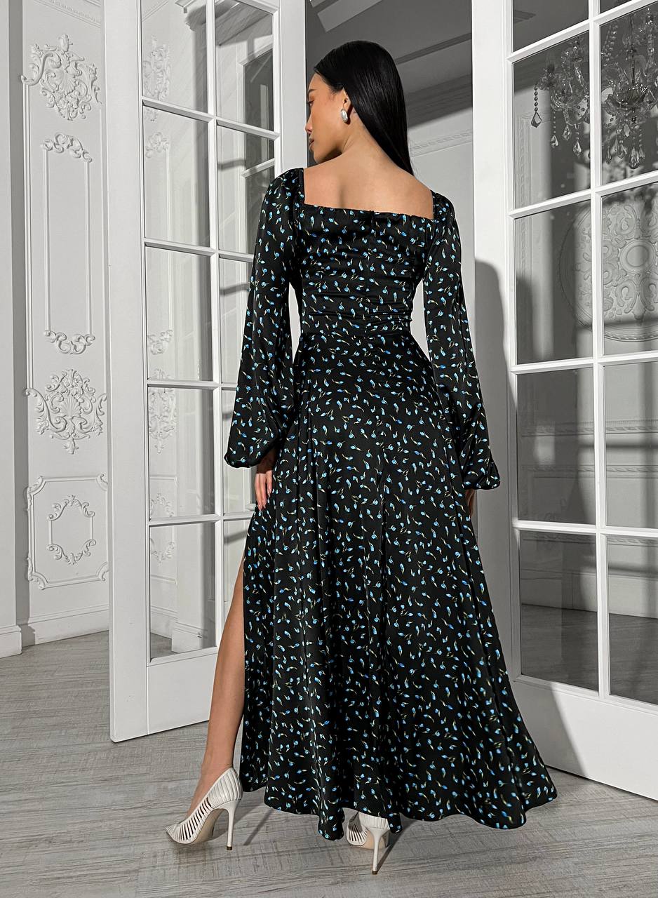 Woman in a black floral dress standing in a room with white doors.
