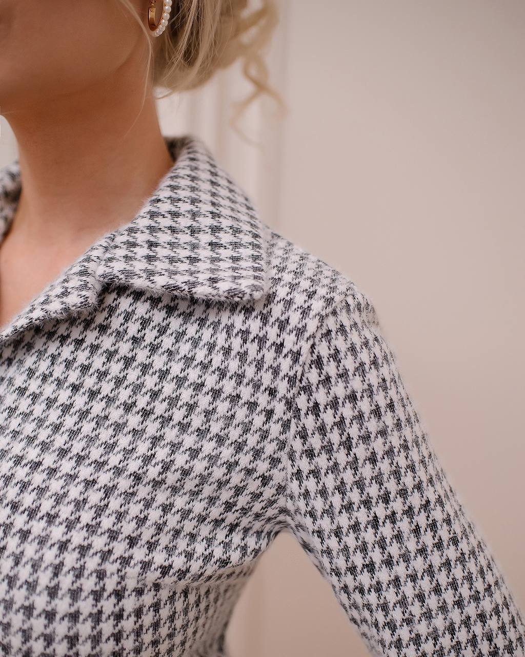 Houndstooth patterned shirt worn by a person with a neutral background