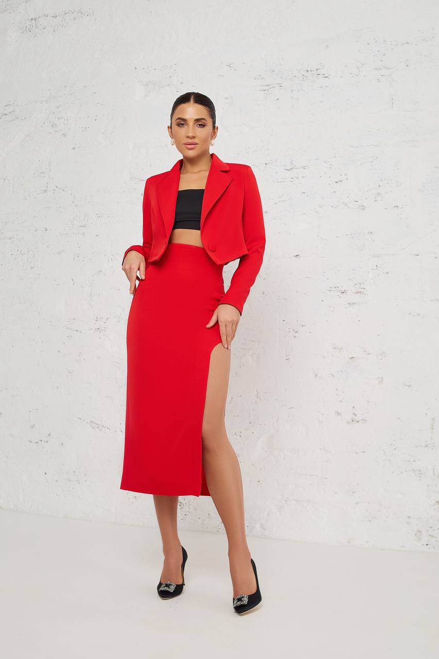 Woman wearing a red outfit with a white brick wall background