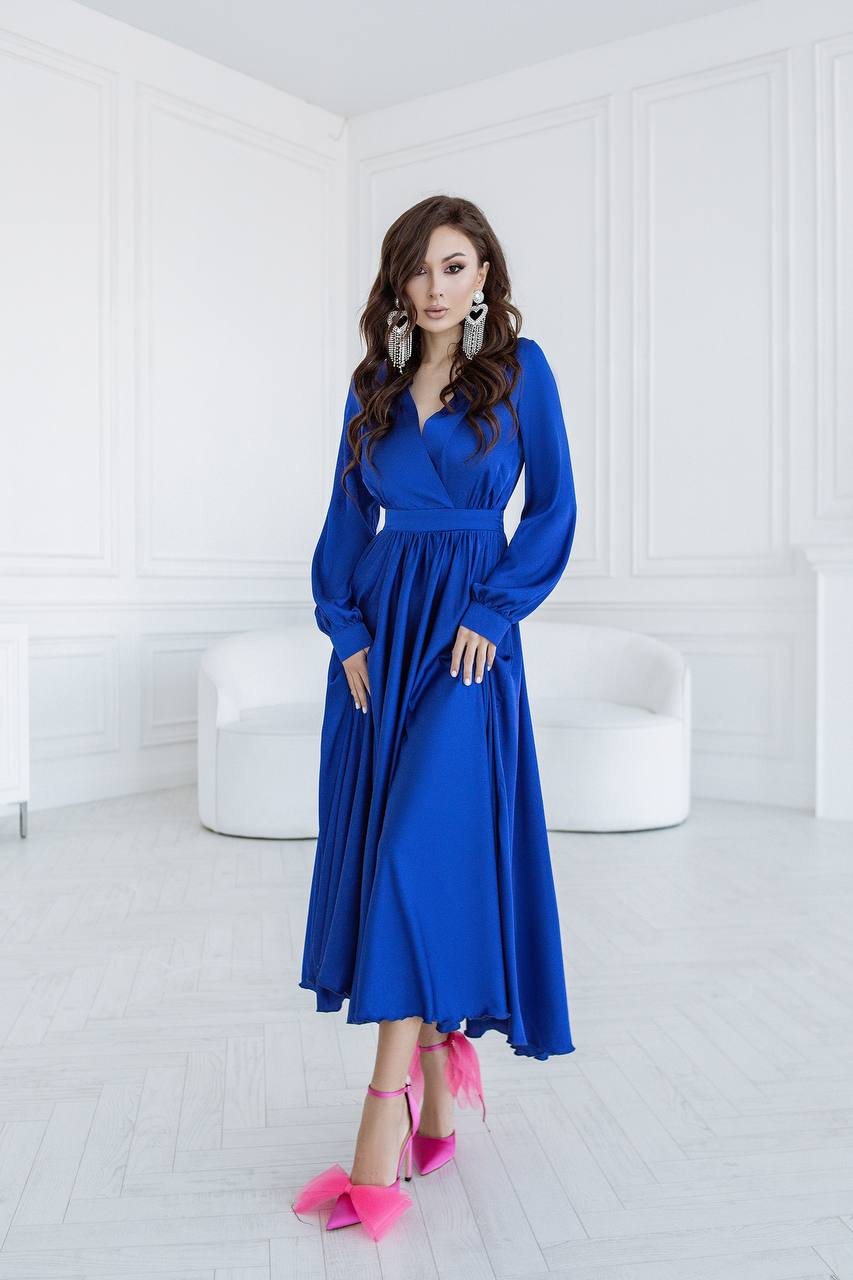Woman in a blue dress standing in a white room