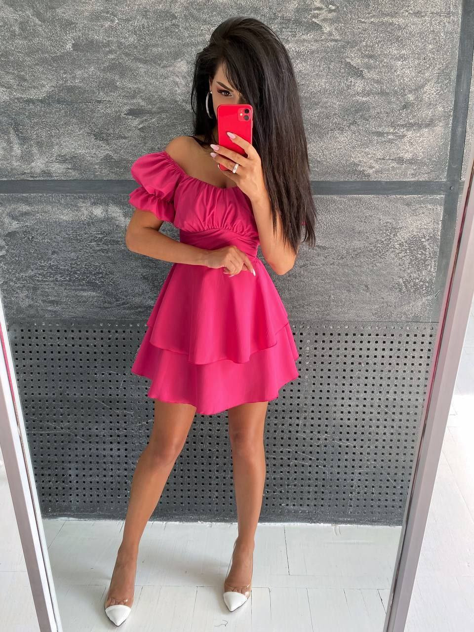 Woman taking a mirror selfie wearing a pink off-shoulder dress.