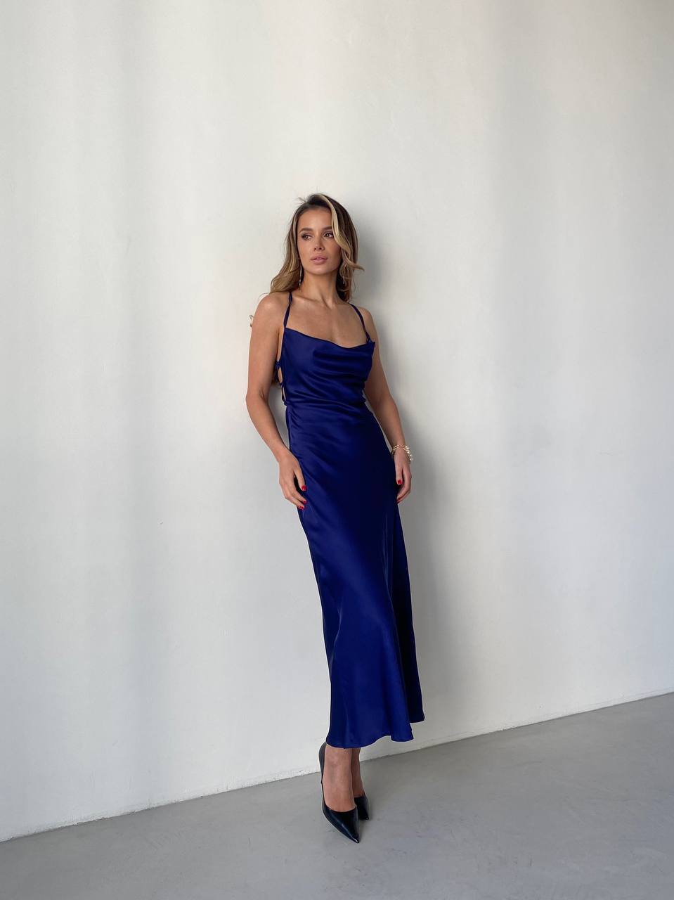 Woman wearing a blue satin dress against a white background